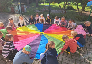 Grupa II - zabawa muzyczna z chustą animacyjną - do piosenki "Po kole krąży plotka"