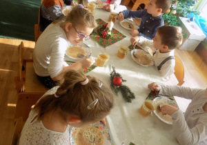 Dzieci z grupy elfów jedzą uroczysty obiad wigilijny.