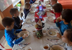 Dzieci z grupy muchomorków jedzą uroczysty obiad wigilijny.