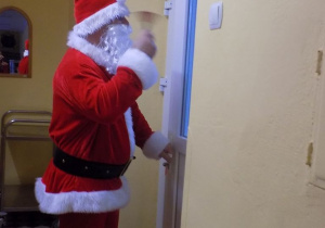 Mikołaj dzwoni dzwonkiem i otwiera drzwi od sali grupy krasnali.