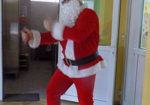 Mikołaj dzwoni dzwonkiem i tańczy na sali gimnastycznej.