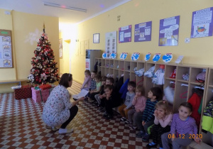 Nauczycielka z grupy muchomorków czyta dzieciom list od Świętego Mikołaja.