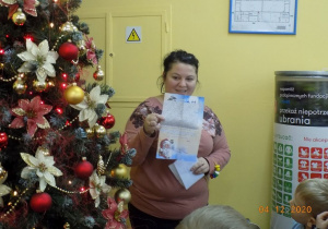 Nauczycielka z grupy skrzatów pokazuje dzieciom list od Świętego Mikołaja.