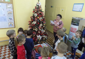 Nauczycielka z grupy skrzatów czyta dzieciom list od Świętego Mikołaja.