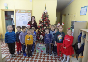 Dzieci i nauczycielka z grupy elfów stoją przy choince.