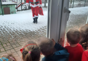 Dzieci wygladaja przez okno na Świętego Mikołaja