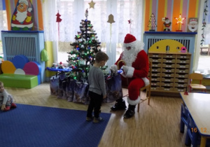 Święty Mikołaj rozdaje paczki świąteczne dzieciom z grupy I