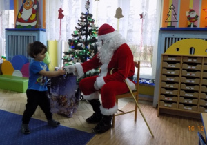 Święty Mikołaj rozdaje paczki świąteczne dzieciom z grupy I