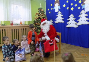 Święty Mikołaj rozdaje paczki świąteczne dzieciom z grupy II