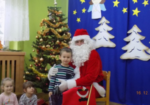 Święty Mikołaj rozdaje paczki świąteczne dzieciom z grupy II