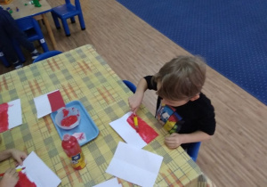 Chłopiec maluje farbami flagę Polski