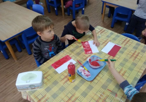 Chłopcy malują farbami flagę Polski