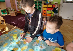 Dzieci malują farbami maski karnawałowe