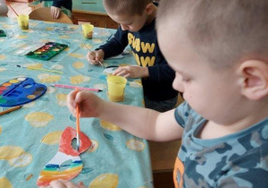 Dzieci malują farbami maski karnawałowe
