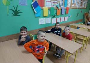Dzieci z grupy III siedzą w szkolnych ławkach