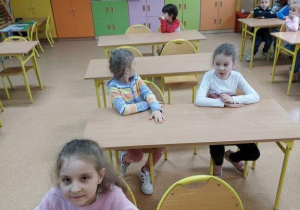 Dzieci z grupy III siedzą w szkolnych ławkach