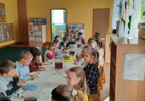 Dzieci jedzą śniadanie wielkanocne.