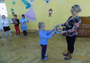 Dzieci odbierają pamiątkowe dyplomy od Pani Dyrektor z uroczystości Pasowania na Starszaka
