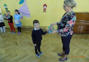 Dzieci odbierają pamiątkowe dyplomy od Pani Dyrektor z uroczystości Pasowania na Starszaka