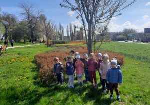 Dzieci na wiosennym spacerze podziwiają budzącą się do życia przyrodę i uczą się nazw kwiatów