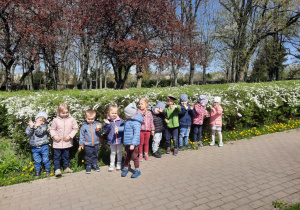 Dzieci na wiosennym spacerze podziwiają budzącą się do życia przyrodę i uczą się nazw kwiatów