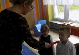 Dyrektor pasuje dzieci ołówkiem na przedszkolaków