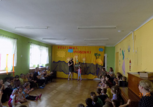 Dzieci, nauczyciele i rodzice biorą udział w Festiwalu Piosenki Wakacyjnej