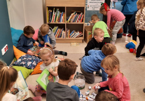 Dzieci biorą udział w zajęciach w bibliotece.