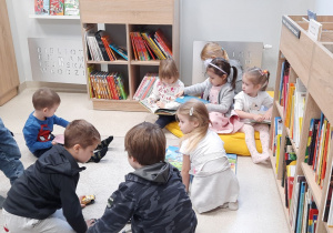 Dzieci biorą udział w zajęciach w bibliotece.
