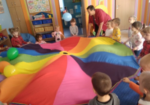 Dzieci bawią się z chustą animacyjną i balonami