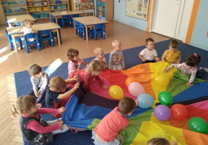 Dzieci bawią się z chustą animacyjną i balonami