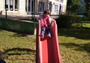Zabawy dzieci w ogrodzie przedszkolnym- zjeżdżalnia