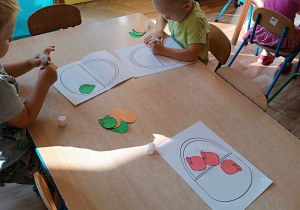 Dzieci liczą papierowe warzywa i owoce