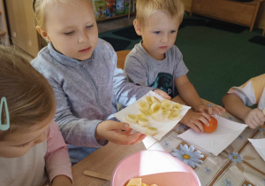 Dzieci robią owocowe szaszłyki