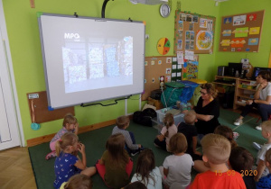 Warsztaty ekologiczne prowadzone przez pracowników działu edukacyjnego MPO dla dzieci 5 - letnich. Dzieci oglądają film edukacyjny na tablicy interaktywnej.