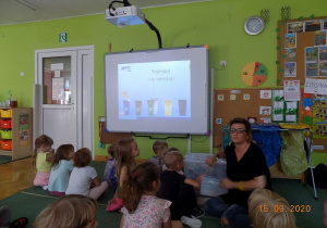 Warsztaty ekologiczne prowadzone przez pracowników działu edukacyjnego MPO dla dzieci 5 -letnich. Dzieci oglądają film edukacyjny na tablicy interaktywnej
