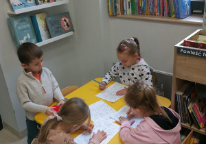 Dziewczynki kolorują obrazki przy stoliku