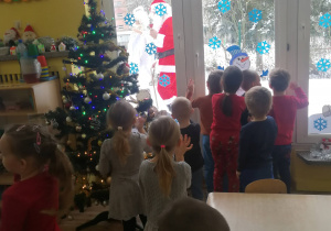 Dzieci widzą Świętego Mikołaja za oknem