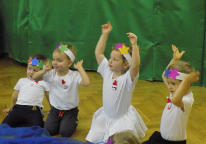 Dzieci przebrane za gwiazdki unoszą ręce w tańcu