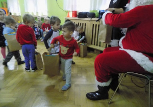 Dziecko z grupy I otrzymuje paczkę świąteczną od Mikołaja