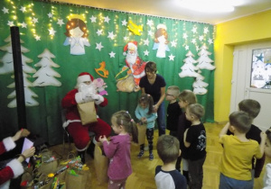 Dziecko z grupy III otrzymuje paczkę świąteczną od Mikołaja