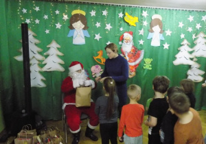 Dziecko z grupy IV otrzymuje paczkę świąteczną od Mikołaja