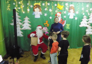 Dziecko z grupy IV otrzymuje paczkę świąteczną od Mikołaja