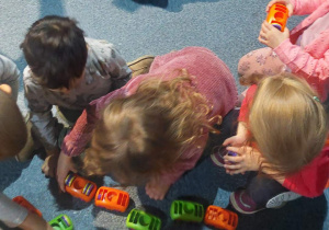 Dzieci bawią się samochodami, które przyciągają się na magnes.