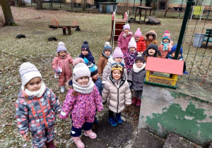 Dzieci zostawiają karmnik w ogrodzie przedszkolnym