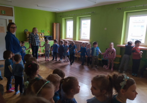 Dzieci bawią się w kole z nauczycielkami przy muzyce.