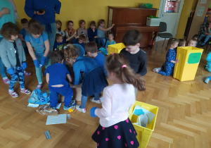 Dzieci biorą udział w konkursie i segregują śmieci.