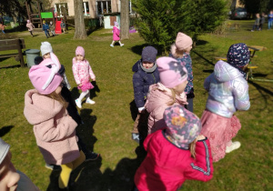 Dzieci szukają wielkanocnego zajączka w ogrodzie
