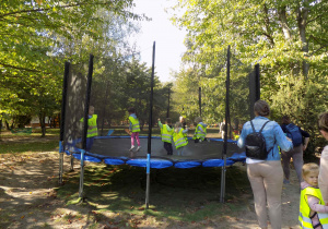 Dzieci skaczą na trampolinie.