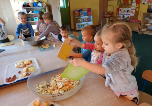 Dzieci wykonują sałatkę owocową, samodzielnie kroją owoce